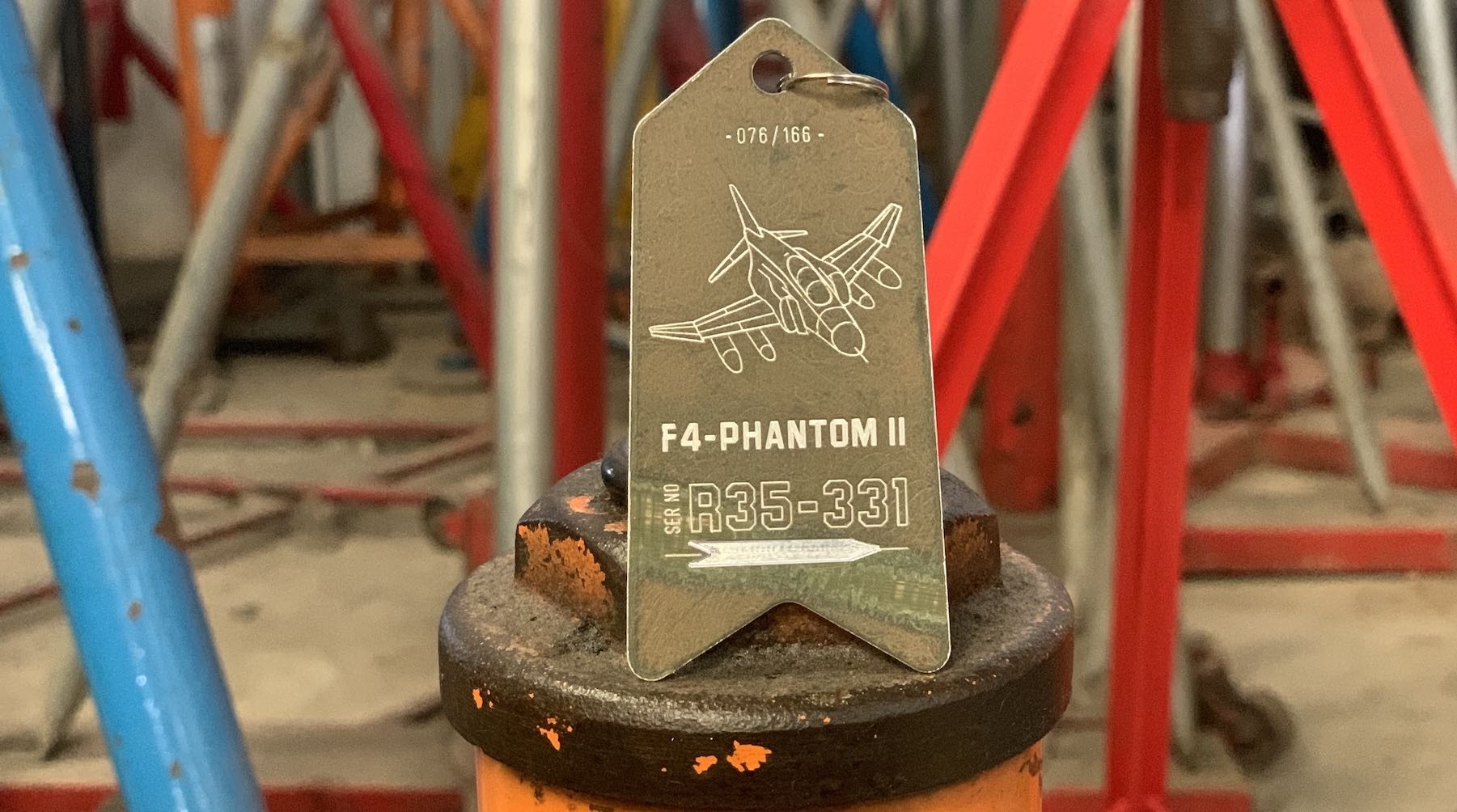 F-4 Phantom II McDonnell Douglas Aircraft Skin Keychain displayed on a colorful background within an airplane repair workshop by Flight Inspiration® - France